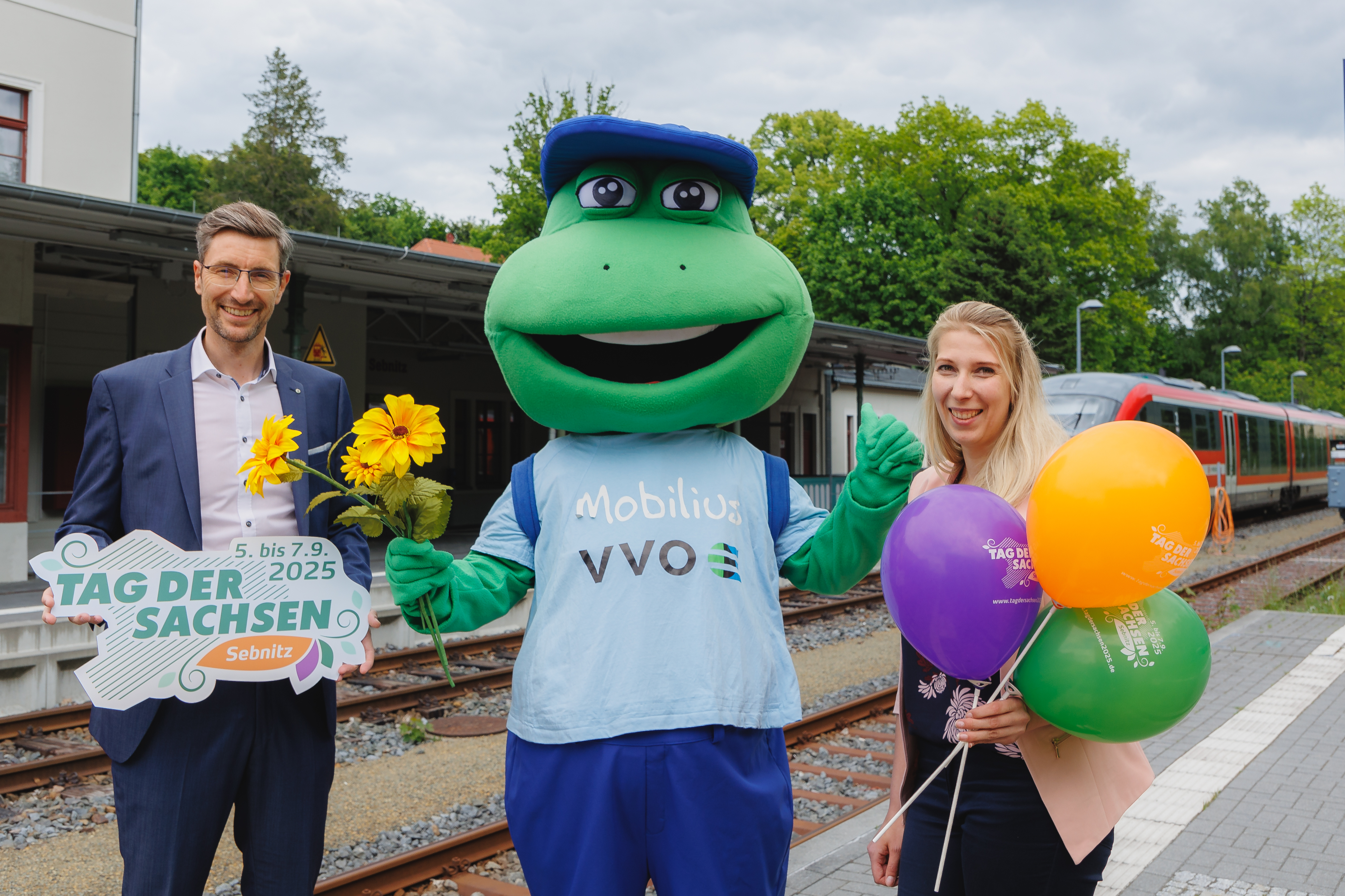 Oberbürgermeister Ronald Kretzschmar, das VVO Maskottchen Mobilius und Marketingverantwortliche Tina Meinert freuen sich über die Kooperation zum "Tag der Sachsen"
